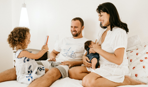 Niña haciendo una foto a una una mujer con bebe y a un hombre