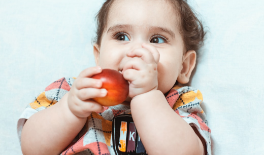 Niño agarrando una fruta con las manos
