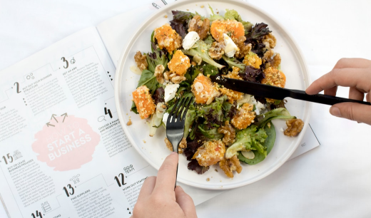 Plato de ensalada y una manos con cubiertos