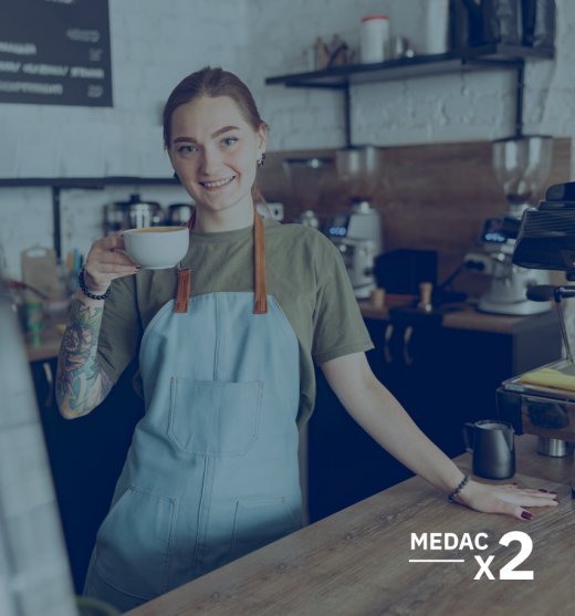 dependienta de una cafetería detrás de la barra con una taza de café en la mano
