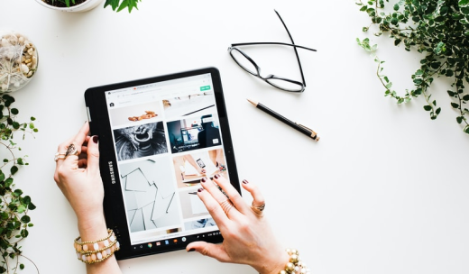 Unas manos de mujer manejando una tablet encima de una mesa