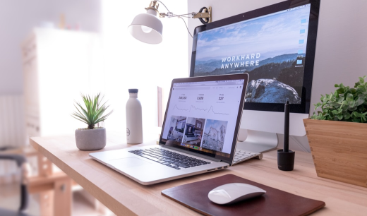 Escritorio con un portatil y una pantalla de ordenador
