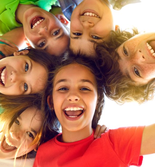 grupo de niños sonriendo mirando a cámara desde arriba
