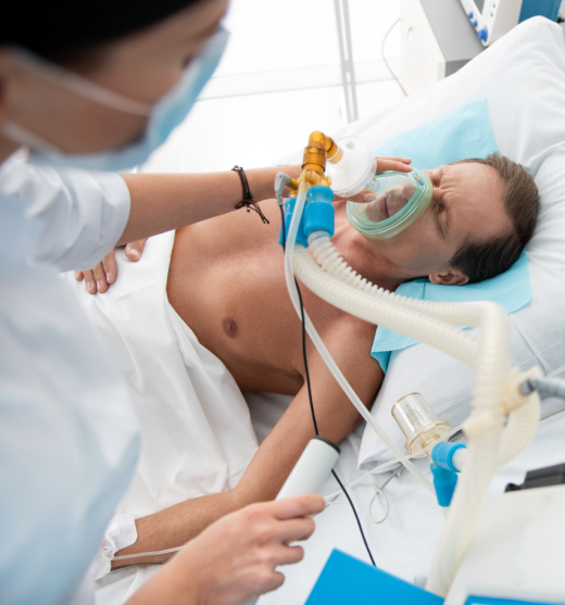 Auxiliar de Enfermería poniendo una máscara de oxígeno a un paciente