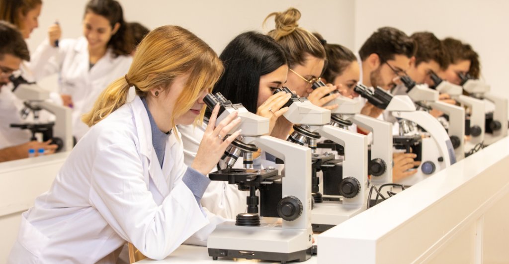 Alumnos mirando por microscopio en MEDAC Córdoba