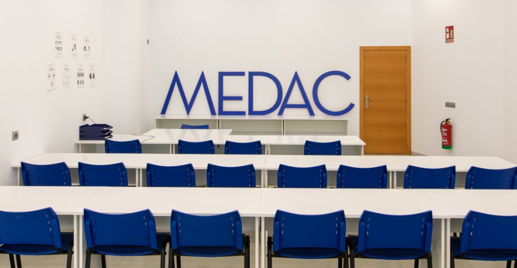 Aula MEDAC con mesas blancas y sillas azules