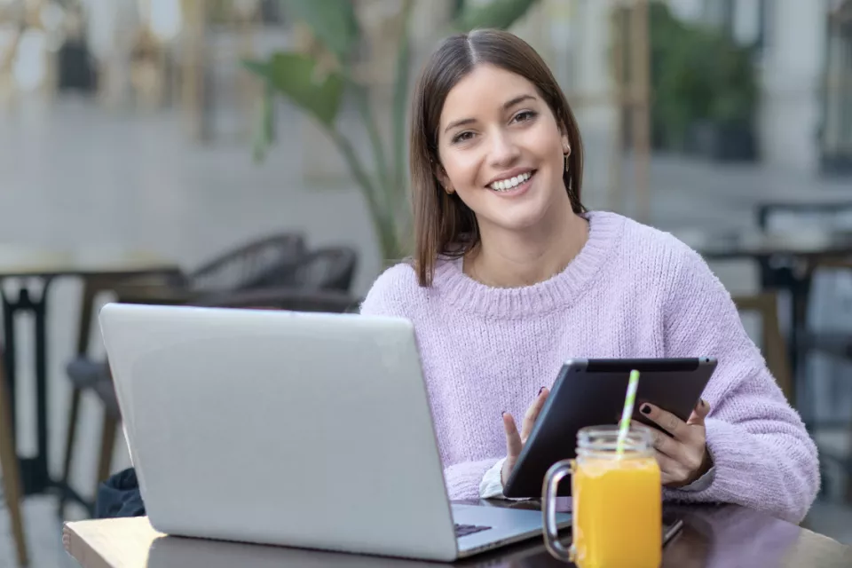 Chica sonriendo con un portatil