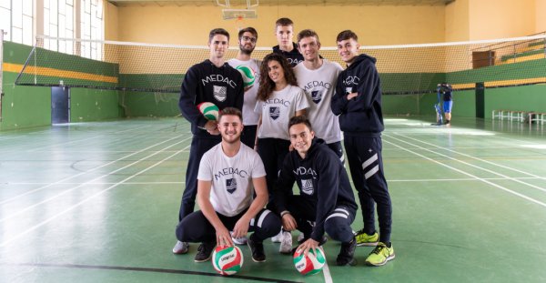 grupo de alumnos de deporte jugando a voleibol