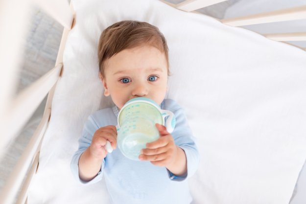 Bebé bebiendo un Biberón de leche con cereales