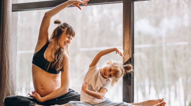 Madre embarazada haciendo ejercicio con su hija