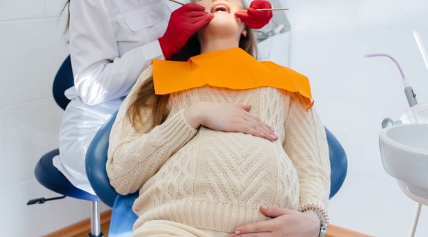 Dentista examinando a una mujer embarazada en una consulta