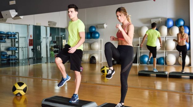 Una mujer y un hombre en una clase de actividad muscular en una sala de ejercicio