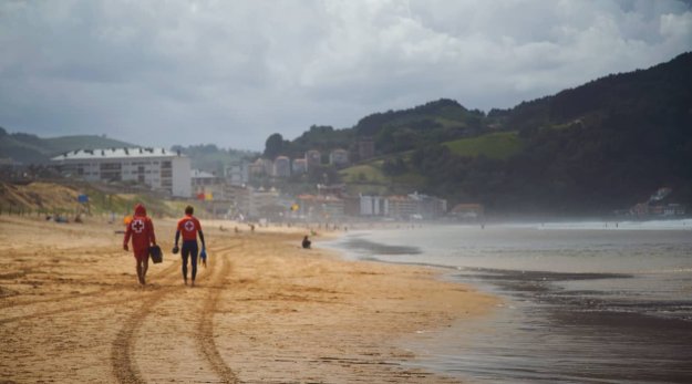 Socorristas andando por la arena de la playa