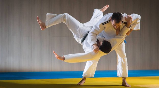 Dos hombres practicando una técnica de judo en un tatami