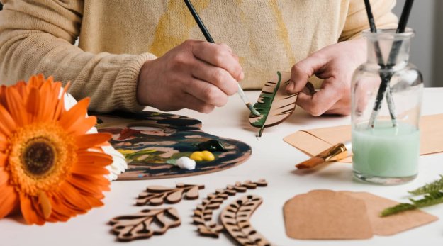 Persona pintando piezas de madera con diferentes colores