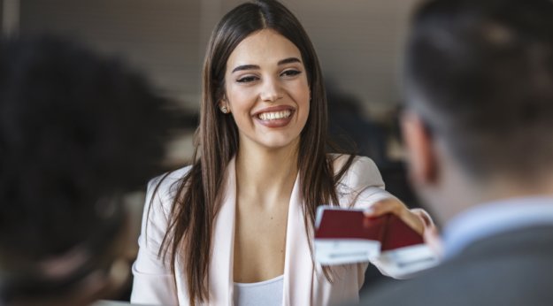 Responsable de una agencia de viajes entregando sus billetes a una pareja