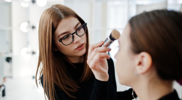 Maquilladora retocando a una cliente