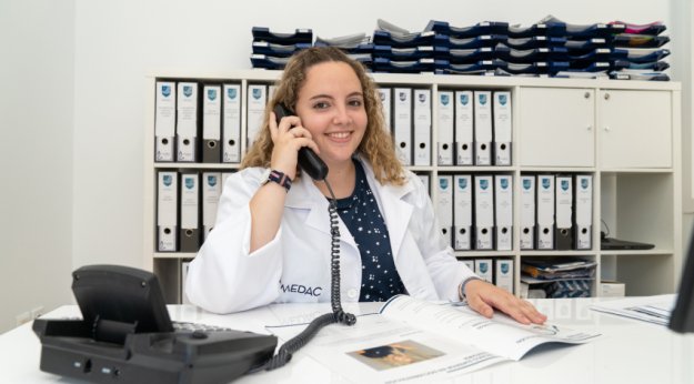 Técnica en Documentación Sanitaria atendiendo llamadas en una oficina sanitaria