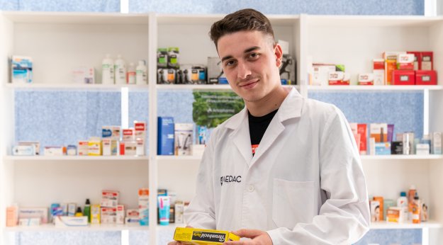 alumno con bata de farmacia en Málaga en un aula taller con medicamentos